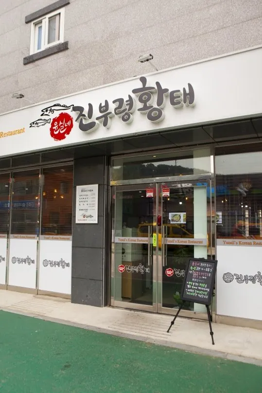 가게 바깥 — 흰 간판과 유리 출입문